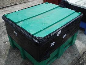A lid sealed on a plastic bin with shrink wrap